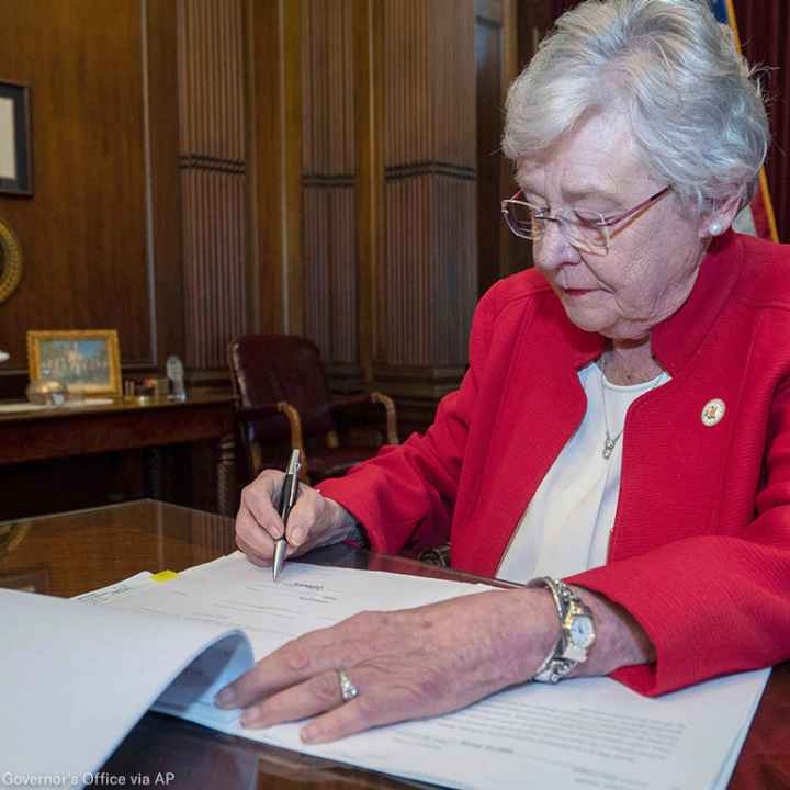 Kay Ivey signing a bill that virtually outlaws abortion in Alabama